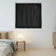 Sort Instant Night-gardin spændt op i en kvadratisk vindueslysning over en seng og et natbord med lampe