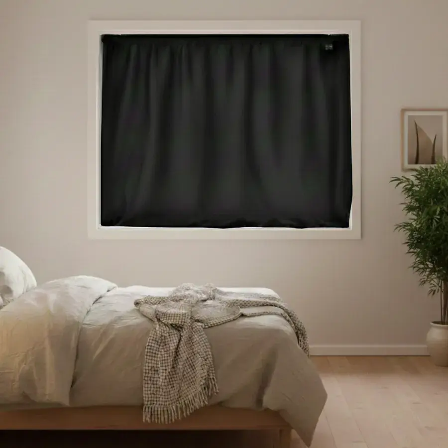 Sort Instant Night-gardin i et bredt vindue over en dobbeltseng med et ternet plaid